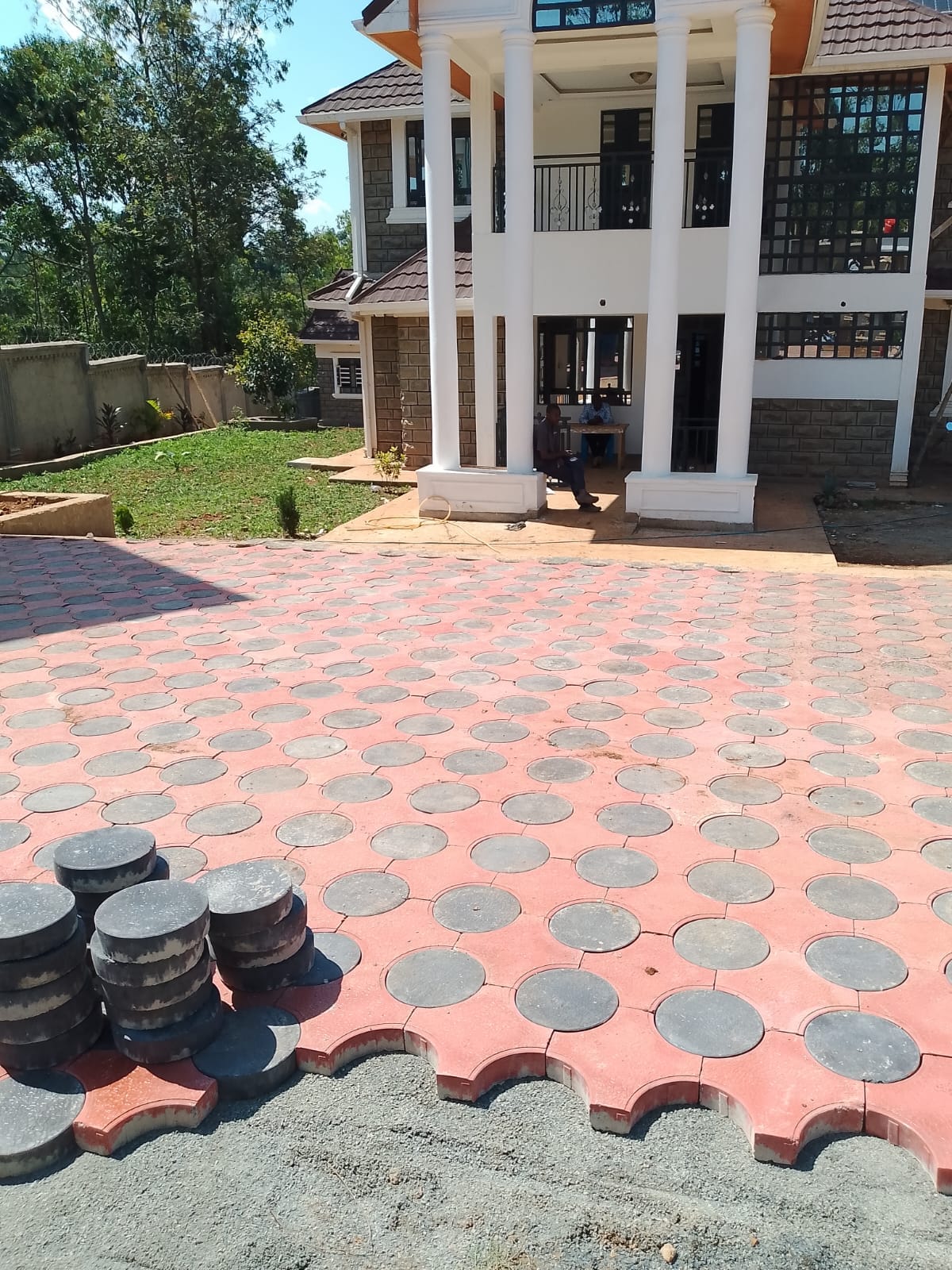 Red scalloped round pavers combined with grey circular paver driveway — UCB Round and Cross Paver installation in Kenya showing decorative interlocking pattern