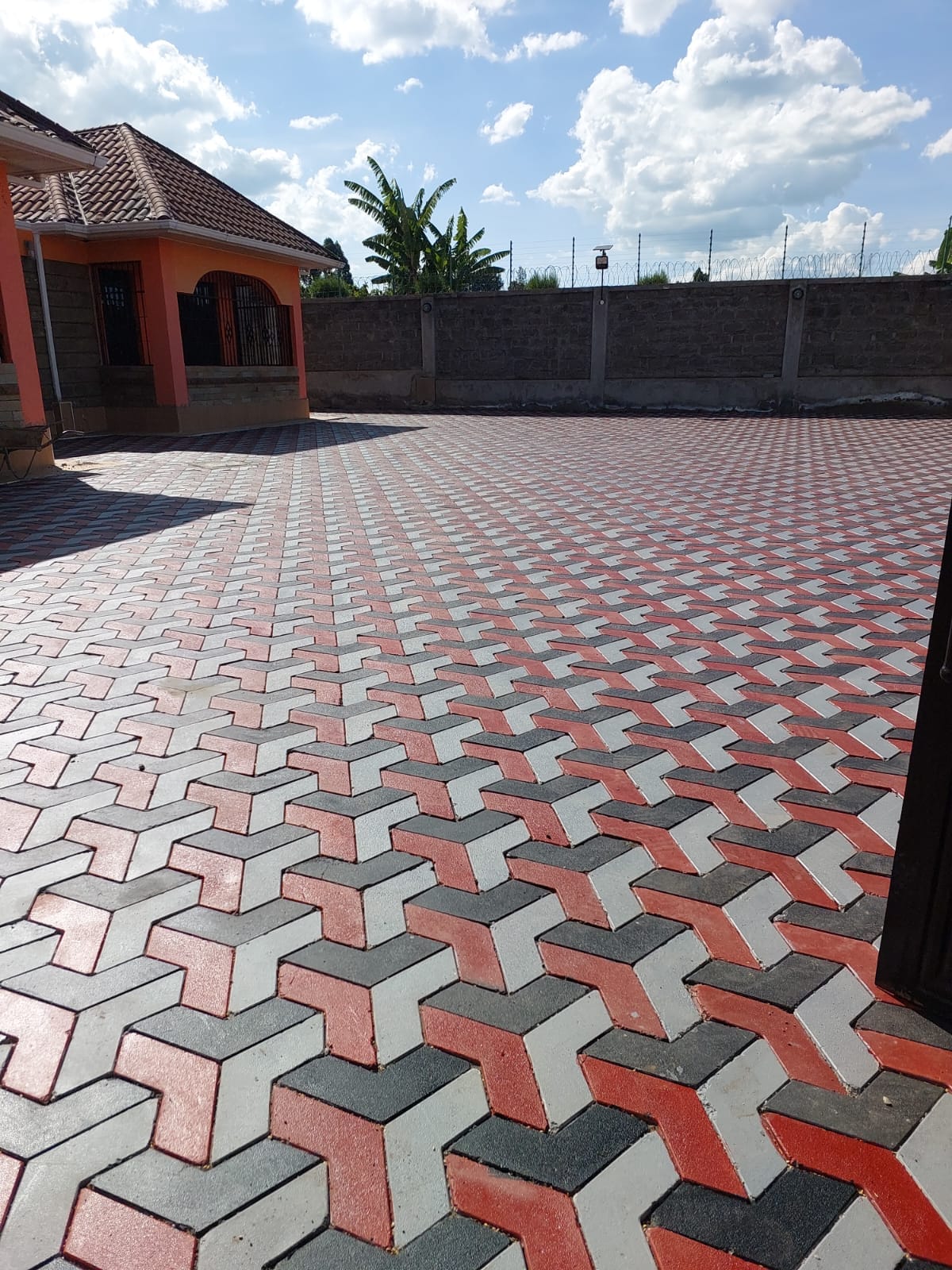 UCB Double T Pavers installed on a residential compound in Kenya — red, grey and dark grey T-shaped interlocking concrete paving blocks by Unique Concrete Builders
